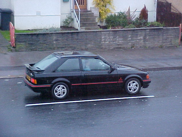 Black Ford Escort XR3i with red trim, side