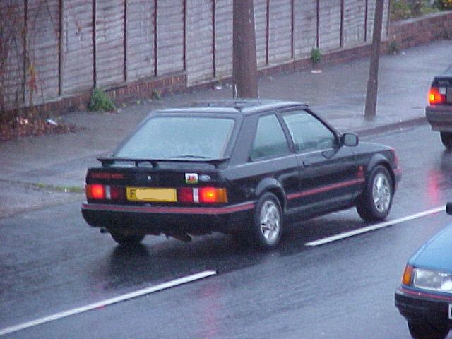 Black Ford Escort XR3i with red trim, rear and side